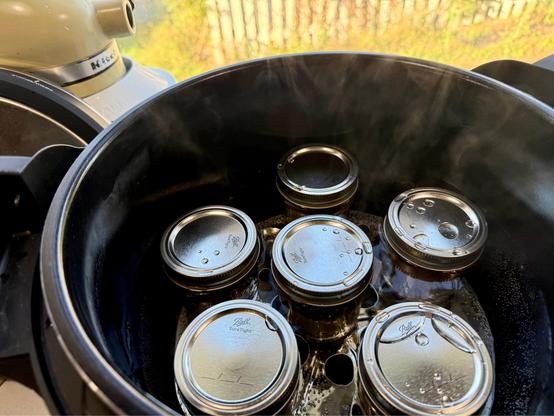 Salsa verde jars in a hot water bath.