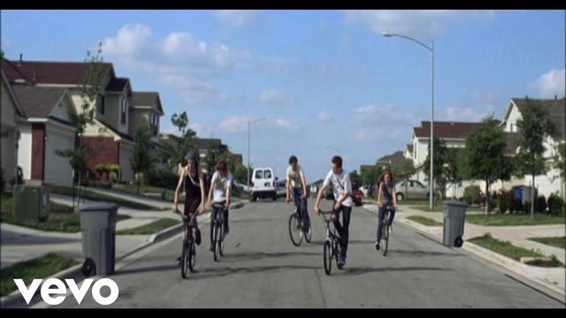 Kids riding their bikes from The Suburbs music video.