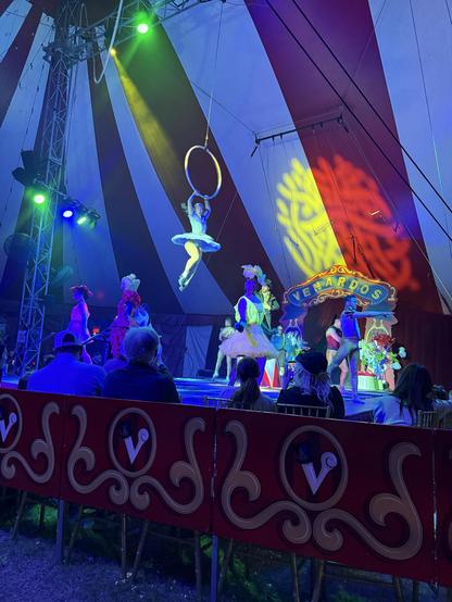 A woman spiraling above a stage on a hoop