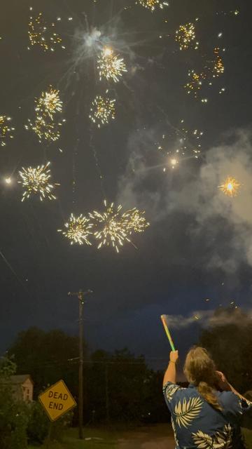 Man in Hawaiian shirt shooting Roman Candles.