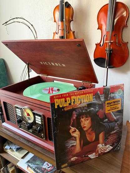 A record player playing a record with the cover for the soundtrack to Pulp Fiction in front of it.