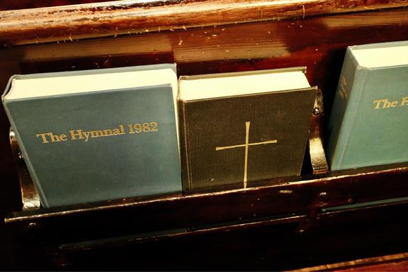 A hymnal and prayer book in a pew