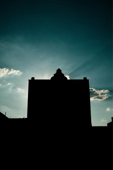A building silhouette with a blue sky.