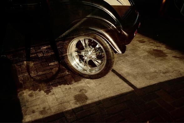 Wheel of a hot rod through a glass window