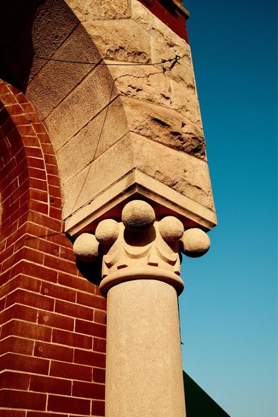 Column surrounded by spherical decorations.